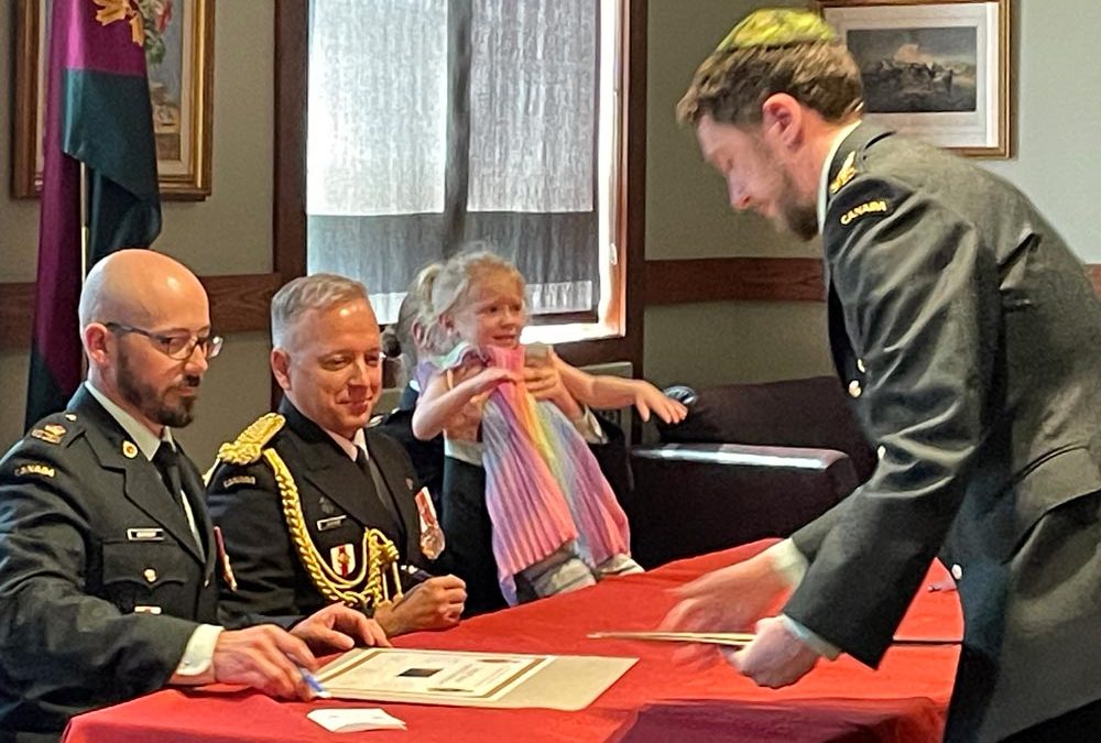 Precocious daughter helps mom sign 11 Health Change of Command scroll